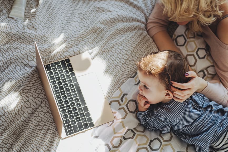 mom boy computer watching laptop bed home